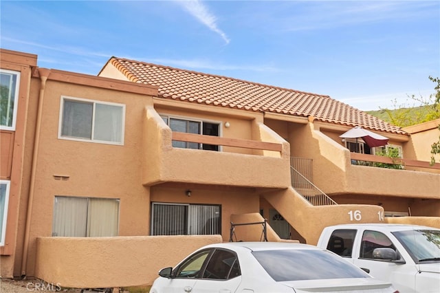 view of front of house featuring a tile roof and stucco siding