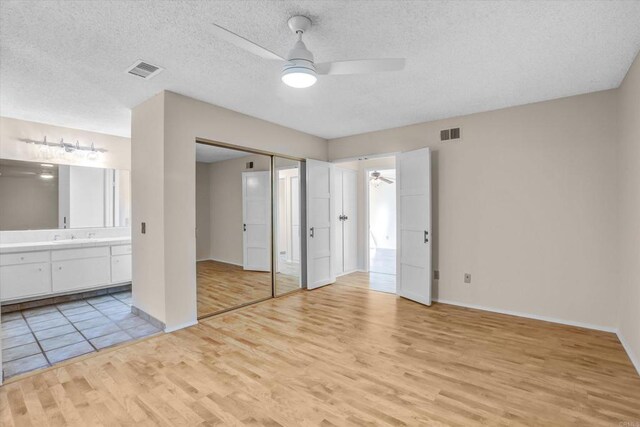 16407 Gabarda Rd, San Diego, CA 92128 - unfurnished bedroom with light wood-style floors, ensuite bathroom, a textured ceiling, and a ceiling fan