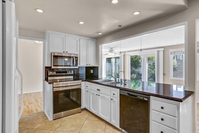 16407 Gabarda Rd, San Diego, CA 92128 - kitchen featuring appliances with stainless steel finishes, a peninsula, dark countertops, white cabinetry, and recessed lighting