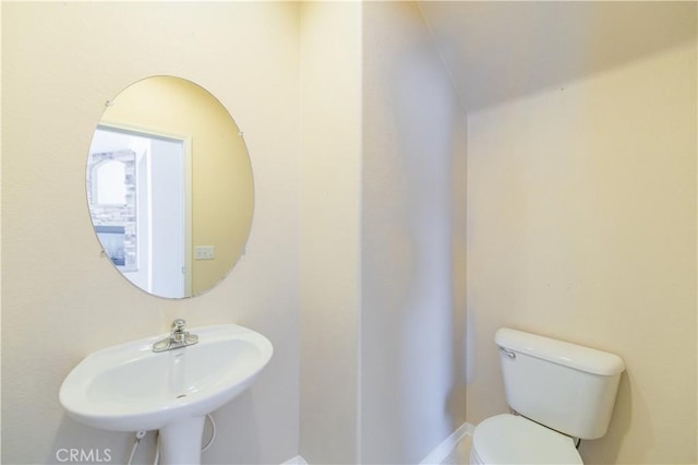 half bathroom featuring toilet and a sink