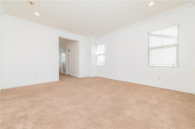 empty room featuring light carpet, ornamental molding, and recessed lighting