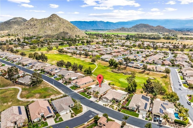 drone / aerial view with view of golf course, a mountain view, and a residential view