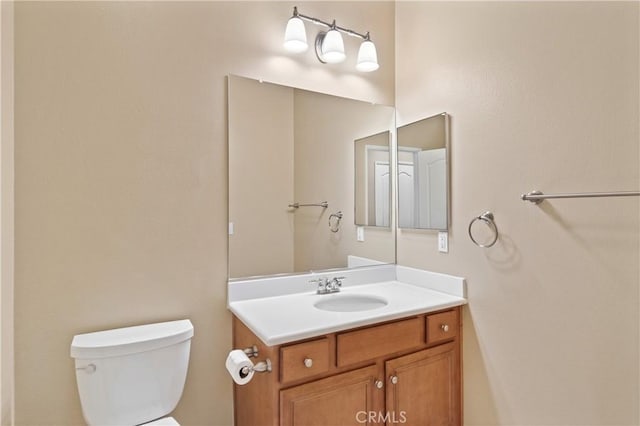 half bathroom featuring vanity and toilet