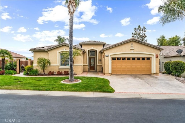 mediterranean / spanish-style house featuring fence, a garage, stucco siding, a front yard, and driveway