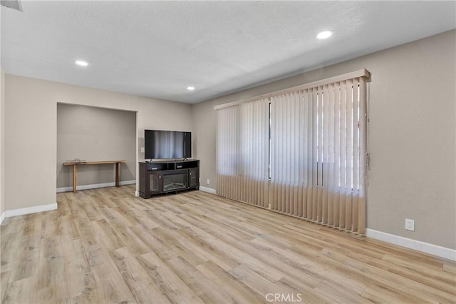 unfurnished living room with visible vents, baseboards, recessed lighting, and wood finished floors