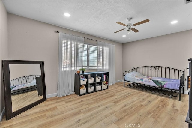 bedroom featuring wood finished floors, baseboards, and recessed lighting