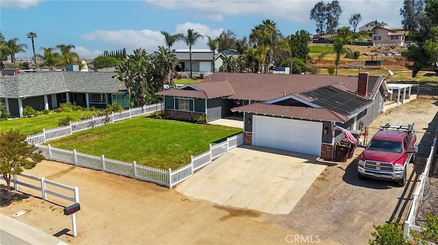ranch-style house featuring an attached garage, driveway, a front yard, and fence private yard