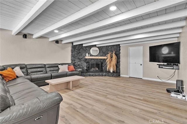 living room featuring baseboards, wooden ceiling, light wood-style floors, a fireplace, and beamed ceiling