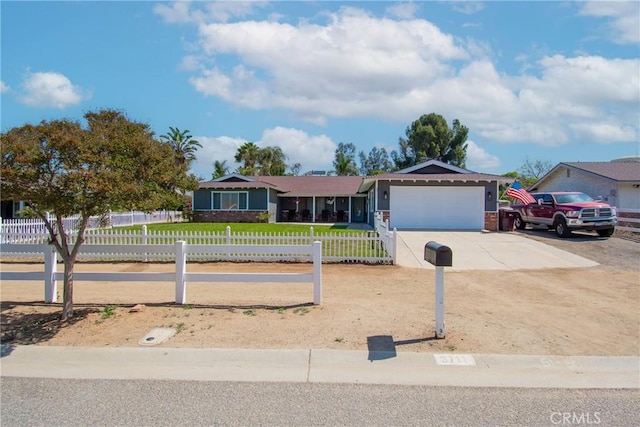 single story home featuring concrete driveway, a front yard, an attached garage, and a fenced front yard