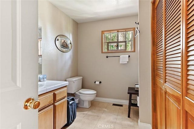 bathroom with vanity, a closet, baseboards, tile patterned floors, and toilet
