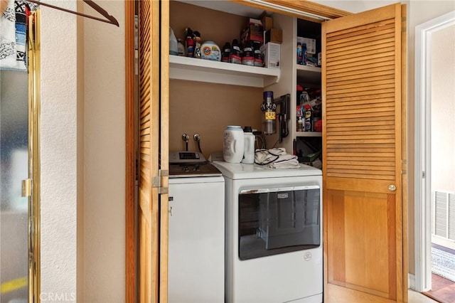 washroom with independent washer and dryer, visible vents, laundry area, and bar