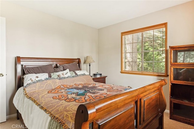 bedroom featuring baseboards and light colored carpet