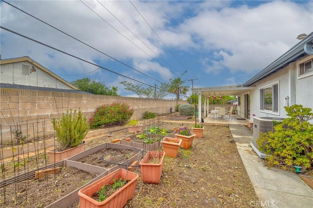 view of yard featuring a patio, a fenced backyard, and a vegetable garden
