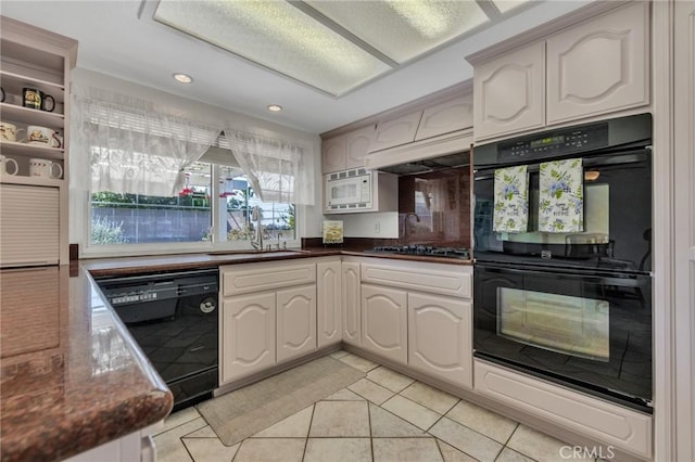 kitchen featuring dark stone countertops, light tile patterned floors, a sink, black appliances, and recessed lighting