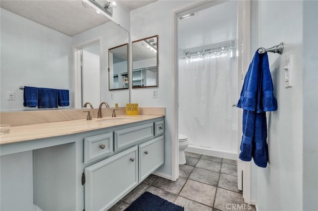 full bathroom featuring toilet, a shower stall, vanity, and a textured ceiling