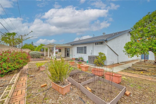 back of property with central AC, stucco siding, a garden, a patio, and fence
