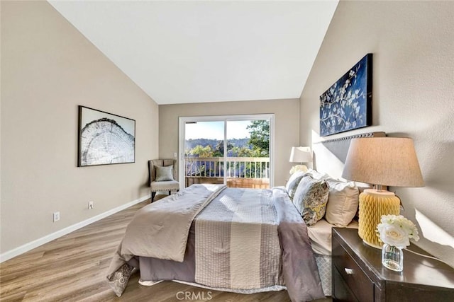 bedroom with baseboards, vaulted ceiling, and wood finished floors