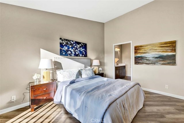 bedroom featuring wood finished floors, ensuite bath, and baseboards
