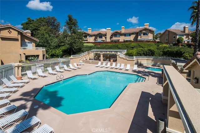 community pool with a residential view, a patio, and fence