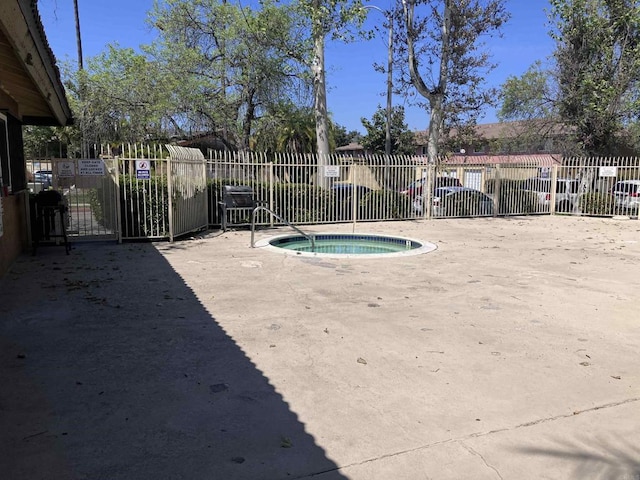 view of pool featuring a community hot tub and fence