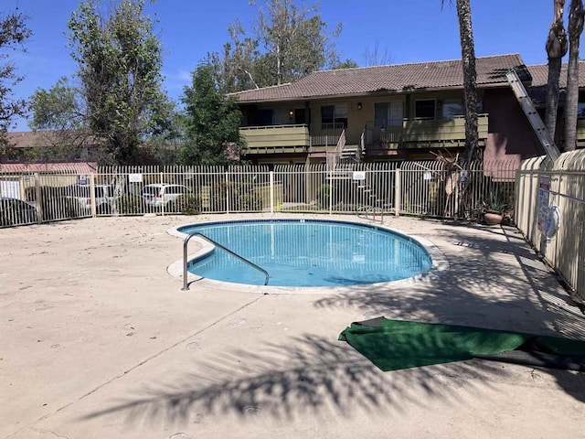 community pool featuring fence and a patio