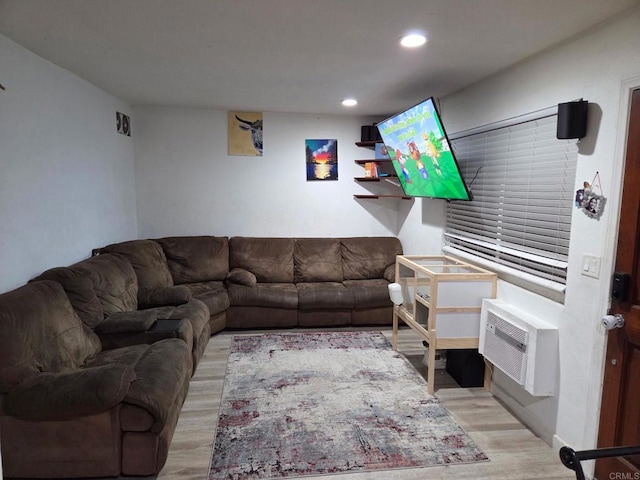 living area with light wood-style floors, a wall unit AC, and recessed lighting