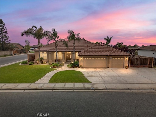 single story home with a tiled roof, a lawn, fence, a garage, and concrete driveway