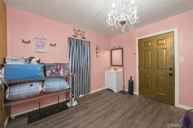 bedroom with a sink, baseboards, an inviting chandelier, and wood finished floors
