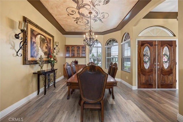dining room featuring baseboards, a notable chandelier, and wood finished floors