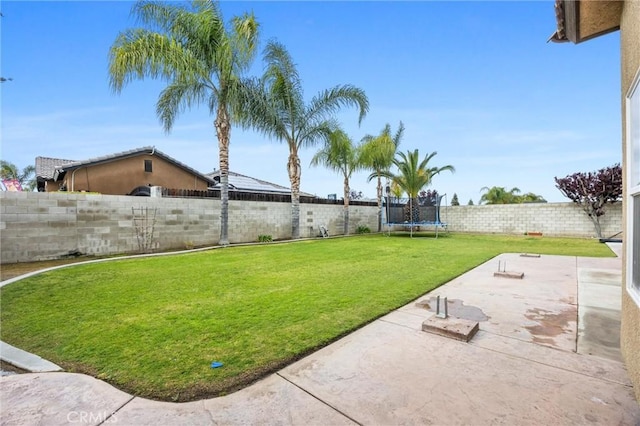 view of yard featuring a fenced backyard, a trampoline, and a patio