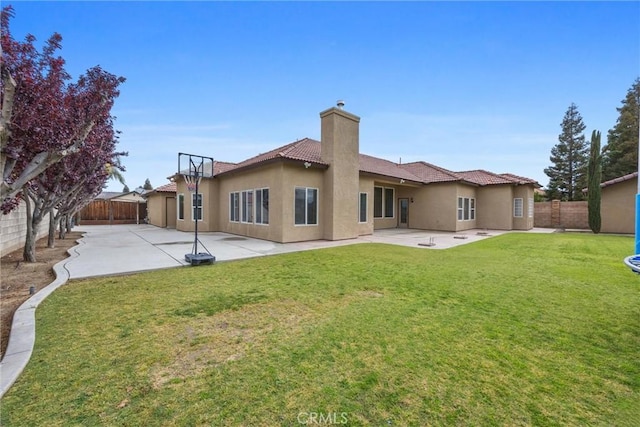 back of house with a fenced backyard, a patio, and stucco siding
