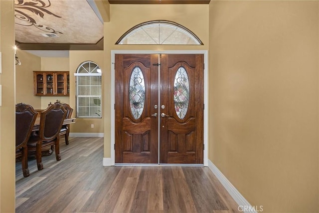 foyer featuring wood finished floors and baseboards