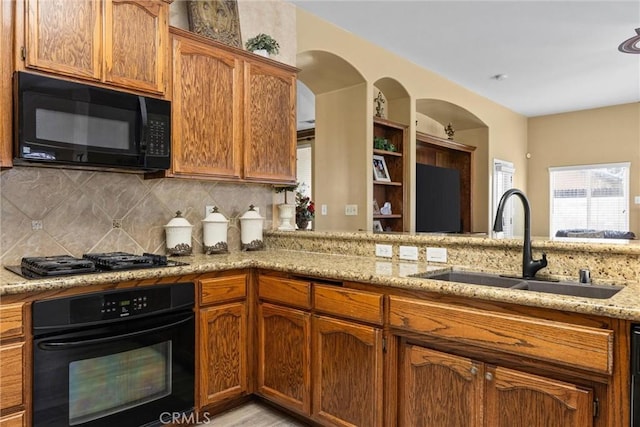 kitchen featuring a sink, tasteful backsplash, and black appliances