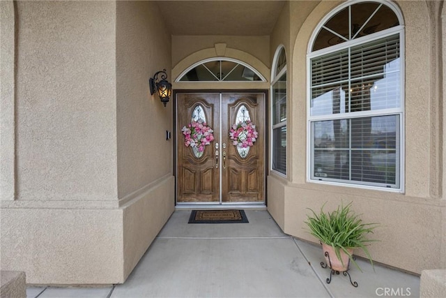 entrance to property featuring stucco siding