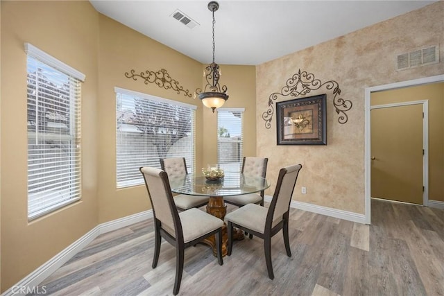 dining room with light wood-style floors, baseboards, and visible vents