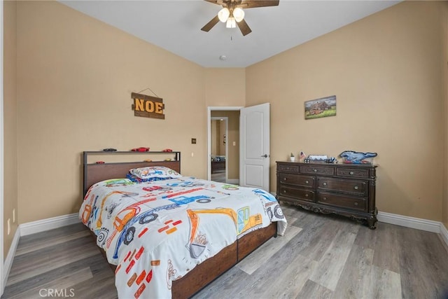 bedroom featuring baseboards, a ceiling fan, and wood finished floors