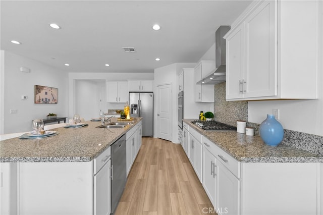 29553 Tulipwood St, Menifee, CA 92584 - kitchen featuring wall chimney range hood, white cabinetry, visible vents, appliances with stainless steel finishes, and a sink