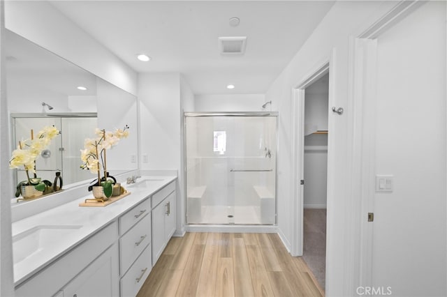 29553 Tulipwood St, Menifee, CA 92584 - full bath featuring double vanity, a shower stall, visible vents, a sink, and wood finished floors