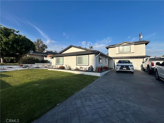 view of front facade featuring a front yard, driveway, stucco siding, and an attached garage