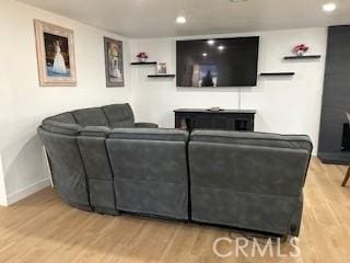 living area featuring baseboards, wood finished floors, and recessed lighting