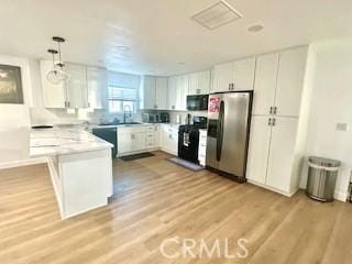 kitchen featuring white cabinets, light countertops, a peninsula, stainless steel refrigerator with ice dispenser, and range
