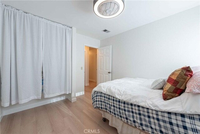 bedroom with light wood-type flooring, baseboards, and visible vents