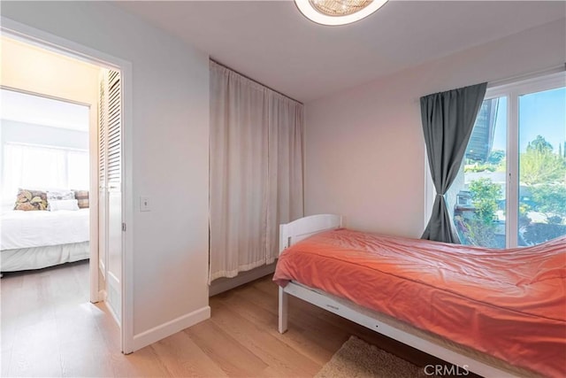 bedroom featuring light wood-style floors and baseboards