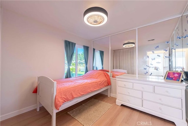 bedroom with light wood-style flooring and baseboards