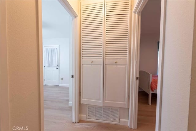 hallway with light wood finished floors and baseboards