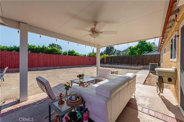 view of patio / terrace featuring central air condition unit, a fenced backyard, and a ceiling fan