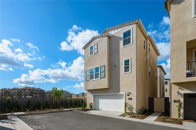 view of front of home featuring an attached garage, driveway, and stucco siding
