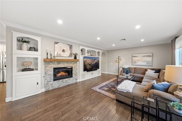 living room with crown molding, visible vents, and wood finished floors