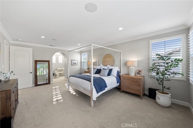 bedroom with crown molding, arched walkways, baseboards, light carpet, and recessed lighting