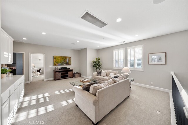 living room with recessed lighting, baseboards, and light colored carpet